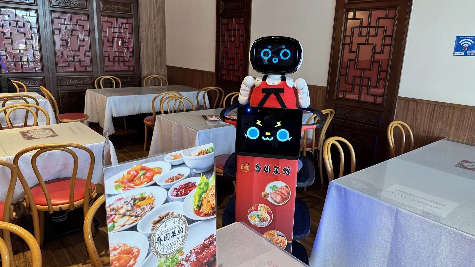飲食店の客席の間を進む配膳中の Collibot