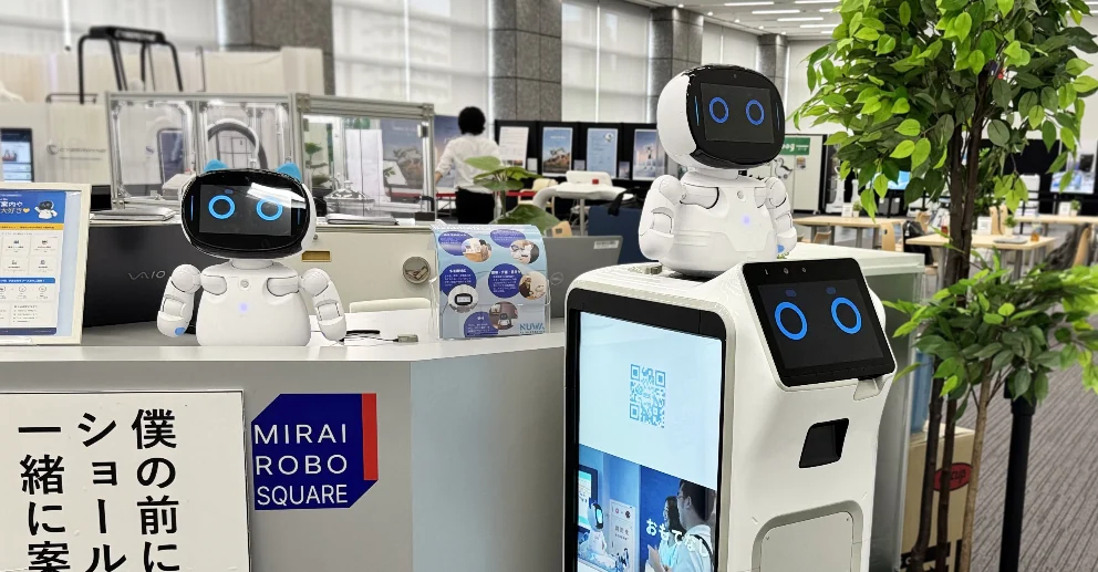 売り場で卓上の Kebbi とサイネージ型 Collibot が並んで案内する、複数構成の運用写真